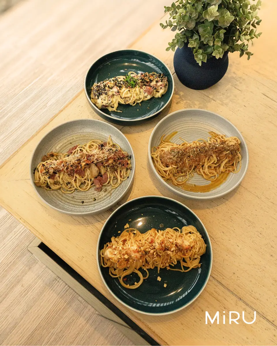 Empat piring spaghetti MiRU difoto dari atas di meja kayu